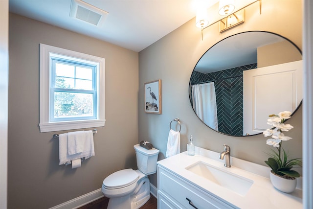 bathroom with vanity, a shower with shower curtain, and toilet