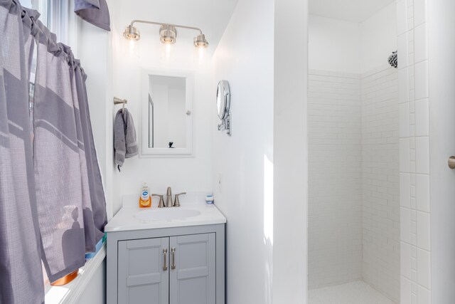 full bath with vanity and tiled shower