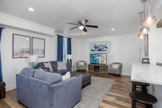 living room featuring dark wood-style floors, recessed lighting, baseboards, and ornamental molding