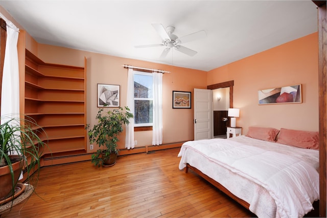 bedroom with a baseboard heating unit, ceiling fan, and light hardwood / wood-style flooring