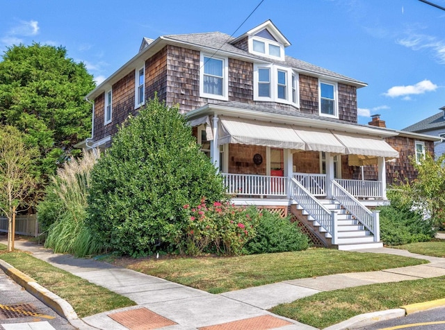 view of front facade featuring covered porch and a front lawn