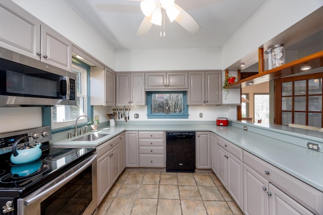 kitchen with a wealth of natural light, appliances with stainless steel finishes, sink, and gray cabinetry