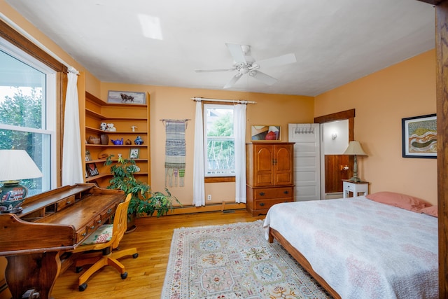 bedroom featuring a baseboard radiator, light hardwood / wood-style floors, and ceiling fan