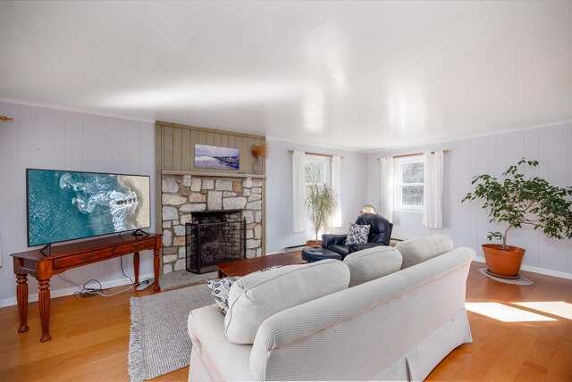 living room with a stone fireplace and light hardwood / wood-style floors