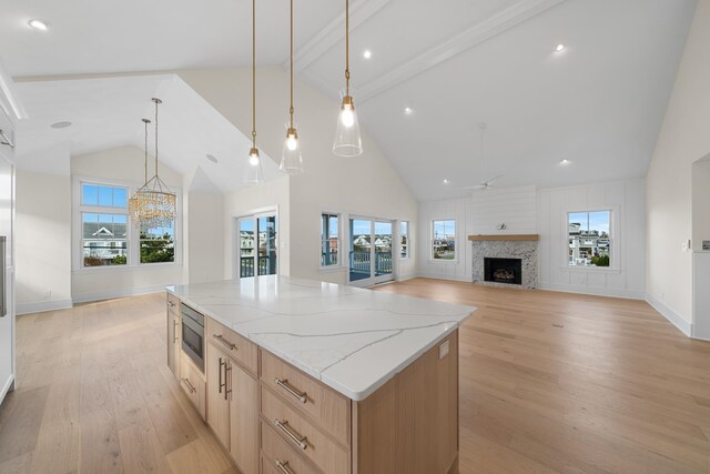 188 34th St, Avalon, NJ 08202 - kitchen featuring high vaulted ceiling, light brown cabinetry, light wood-type flooring, a fireplace, and stainless steel microwave