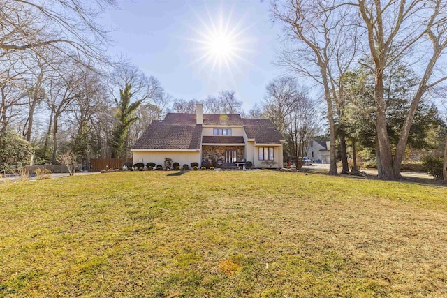 6 Rabbit Run, North Cape May, NJ 08204 - rear view of property with fence, stucco siding, a chimney, and a lawn
