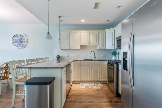 415 E Heather Rd Unit 105, Wildwood Crest, NJ 08260 - kitchen with appliances with stainless steel finishes, a peninsula, a sink, a kitchen bar, and stone counters