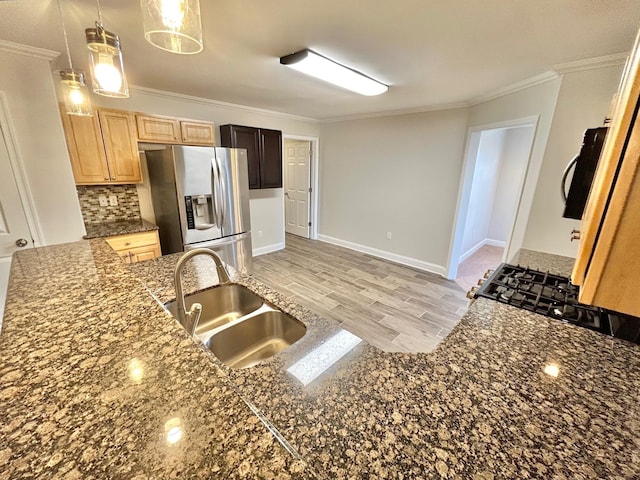 kitchen with stainless steel fridge with ice dispenser, ornamental molding, sink, decorative light fixtures, and backsplash