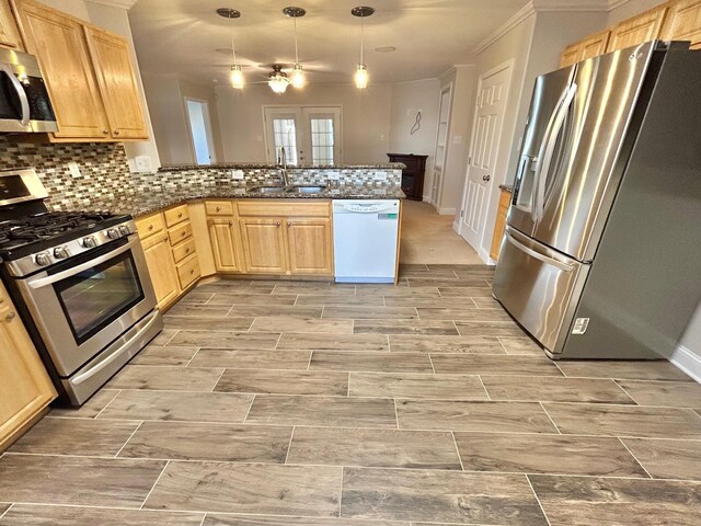 kitchen featuring kitchen peninsula, light brown cabinetry, appliances with stainless steel finishes, and sink