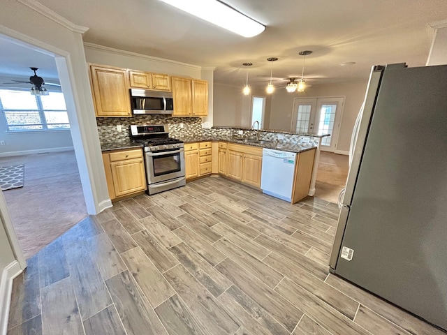 kitchen featuring light hardwood / wood-style flooring, kitchen peninsula, light brown cabinetry, pendant lighting, and appliances with stainless steel finishes