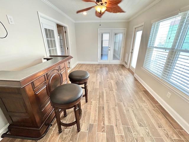 bar featuring ceiling fan, french doors, crown molding, and light hardwood / wood-style floors