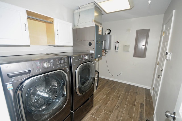 clothes washing area with washing machine and dryer, electric panel, cabinets, and water heater