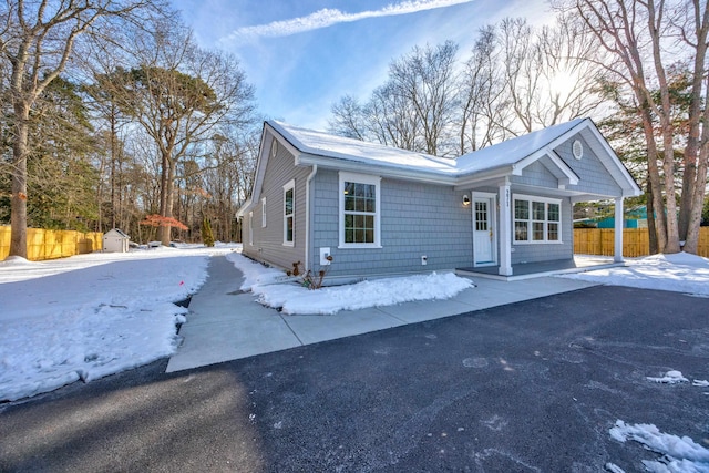 view of front of property featuring a storage shed