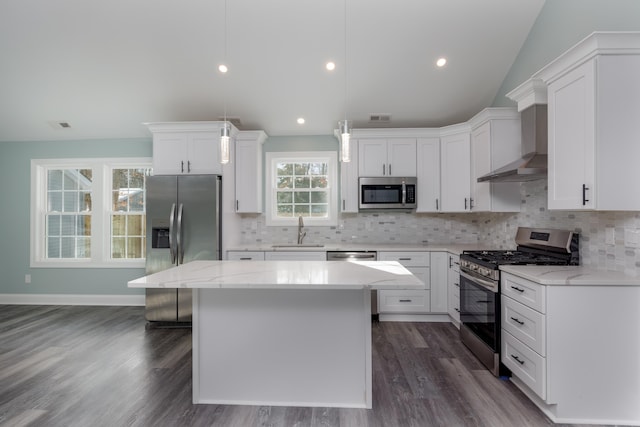 kitchen featuring decorative light fixtures, a center island, sink, and stainless steel appliances