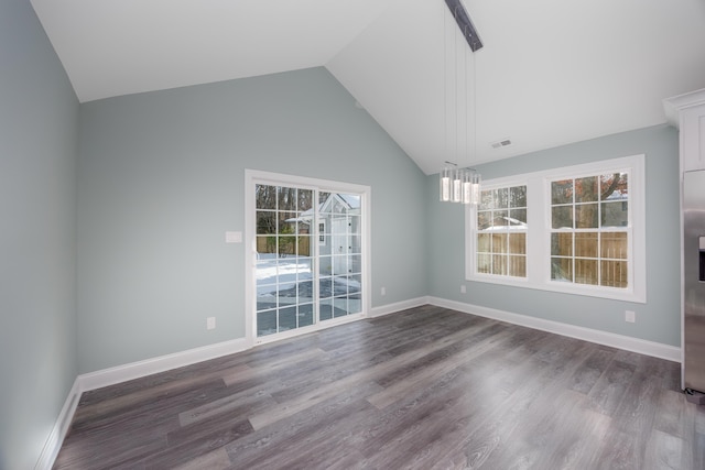 interior space featuring a wealth of natural light, dark wood-type flooring, and vaulted ceiling