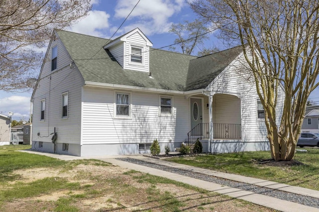 new england style home featuring roof with shingles and a front lawn