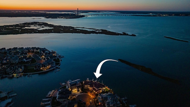 aerial view at dusk featuring a water view