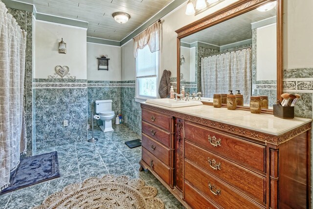 bathroom with toilet, tile walls, wainscoting, tile patterned flooring, and ornamental molding