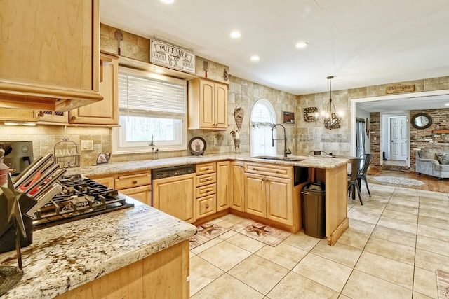 kitchen with a peninsula, light brown cabinetry, a sink, backsplash, and dishwasher