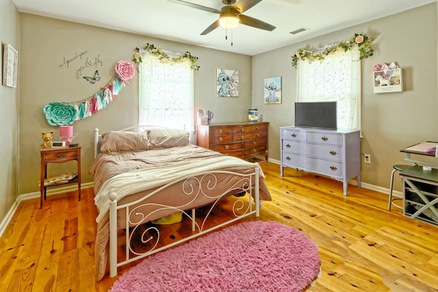 bedroom featuring wood finished floors, a ceiling fan, and baseboards