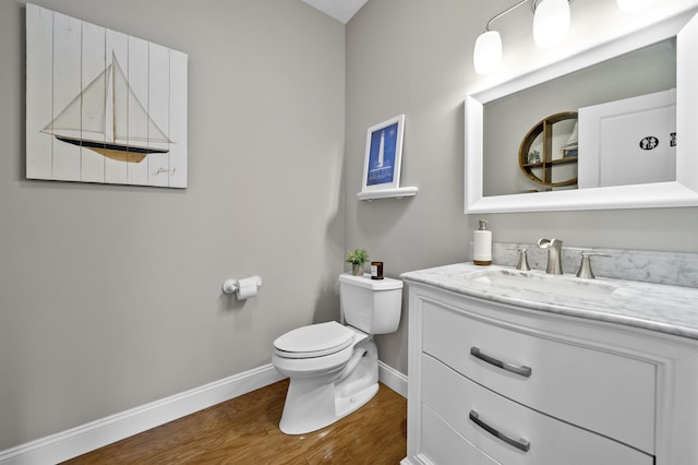 bathroom featuring vanity, wood finished floors, toilet, and baseboards