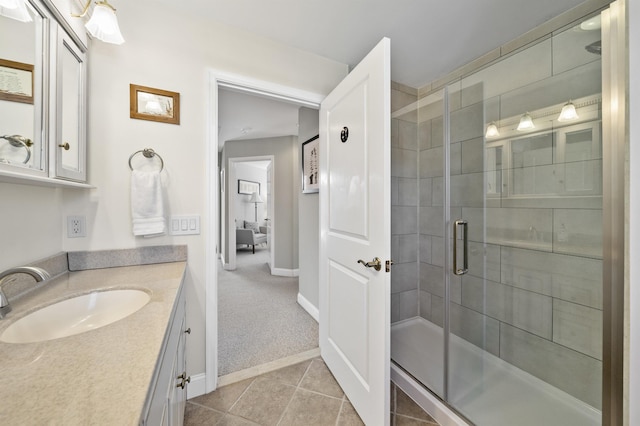 bathroom featuring a shower stall, vanity, baseboards, and tile patterned floors