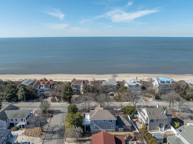 drone / aerial view featuring a view of the beach, a residential view, and a water view