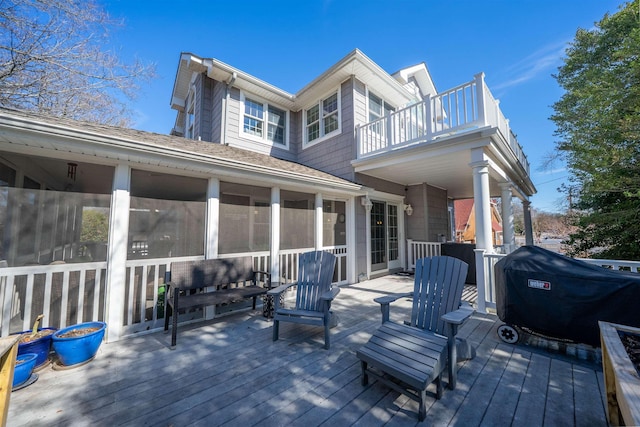 wooden terrace featuring a grill and a sunroom