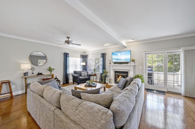 living room featuring baseboards, ornamental molding, and hardwood / wood-style floors