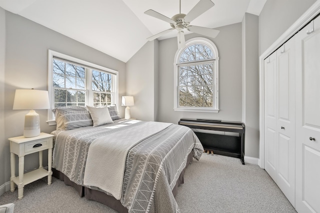 bedroom with vaulted ceiling, a closet, carpet flooring, and baseboards