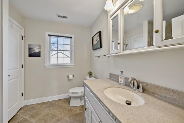 bathroom featuring toilet, vanity, visible vents, baseboards, and tile patterned floors