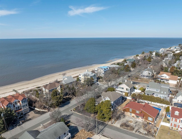 drone / aerial view featuring a water view, a view of the beach, and a residential view