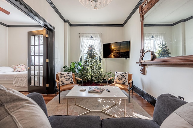 living room with a notable chandelier, wood-type flooring, and crown molding