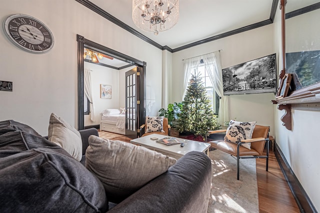 living room with ornamental molding, wood-type flooring, and an inviting chandelier