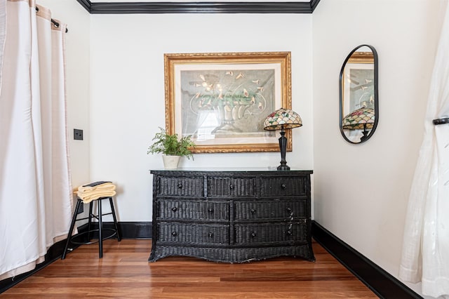 hallway with wood-type flooring and crown molding