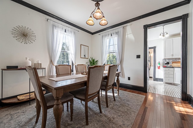 dining space featuring a chandelier, dark hardwood / wood-style floors, and crown molding