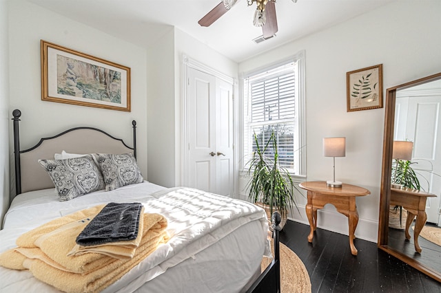 bedroom featuring ceiling fan, a closet, and dark wood-type flooring