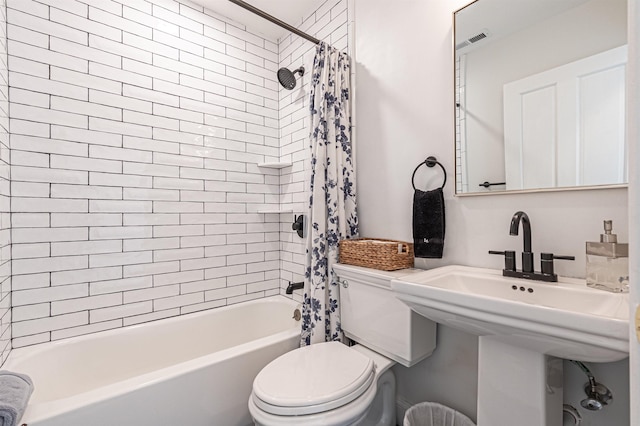 bathroom with shower / bath combo and toilet