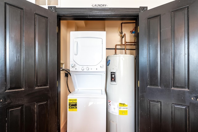 laundry area with stacked washer / drying machine and electric water heater