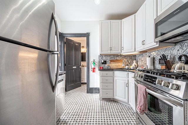 kitchen featuring white cabinetry, appliances with stainless steel finishes, and tasteful backsplash