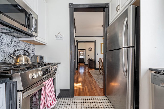 kitchen featuring white cabinetry, stainless steel appliances, and tasteful backsplash