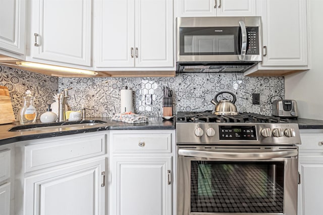 kitchen featuring decorative backsplash, white cabinetry, sink, and appliances with stainless steel finishes