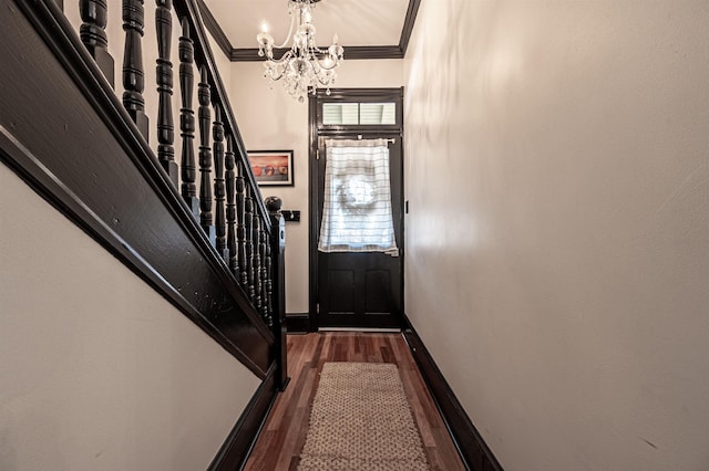 foyer featuring a chandelier, dark hardwood / wood-style floors, and crown molding