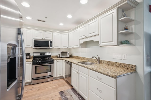 410 E Orchid Rd Unit 202, Wildwood Crest, NJ 08260 - kitchen featuring appliances with stainless steel finishes, light wood-style flooring, recessed lighting, white cabinetry, and light stone countertops