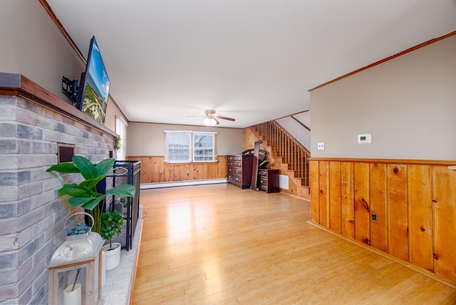 103 Bate Ave, Lower Township, NJ 08204 - unfurnished living room featuring a baseboard radiator, wood walls, light hardwood / wood-style floors, and crown molding