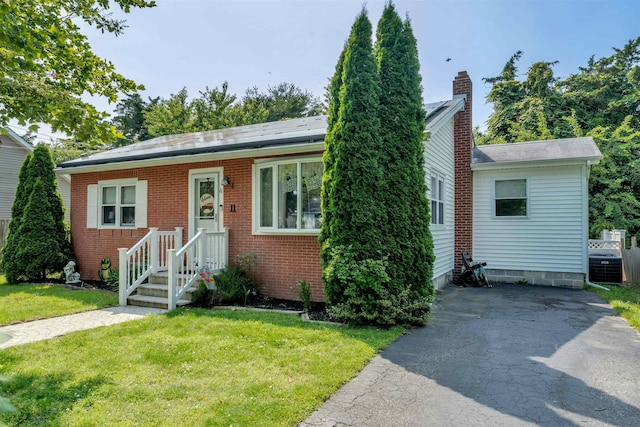 11 S 9th St, Del Haven, NJ 08251 - bungalow-style house with a front lawn, a chimney, and brick siding