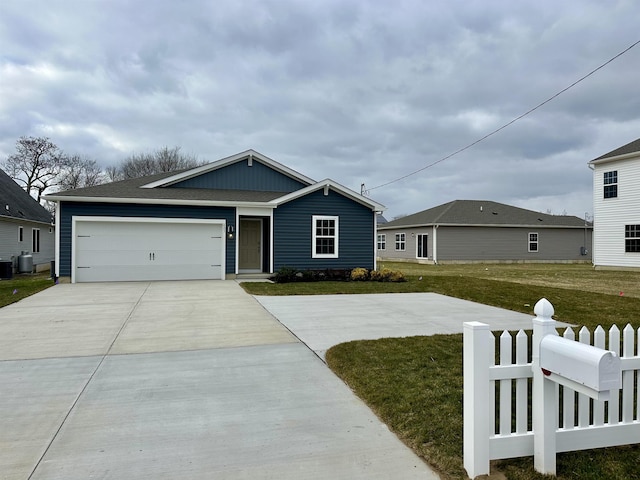 view of front of property featuring a garage, a front lawn, and cooling unit