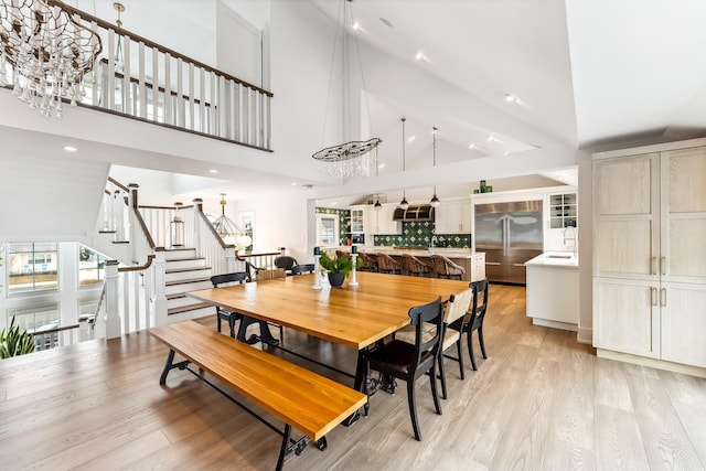 7749 Dune Dr, Avalon, NJ 08202 - dining space with high vaulted ceiling, stairway, light wood finished floors, a chandelier, and recessed lighting
