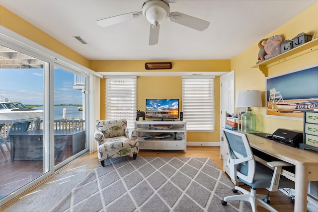 office area with a ceiling fan, visible vents, and wood finished floors