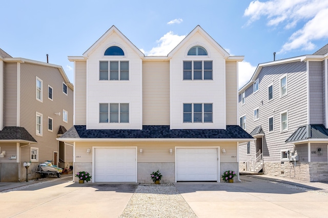 view of front of house featuring a garage, concrete driveway, and a shingled roof